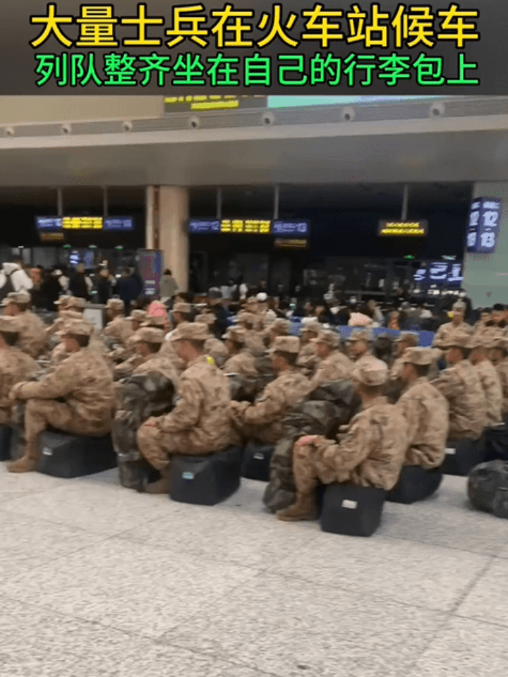 大量士兵在火车站候车 列队整齐坐在自己的行李袋上