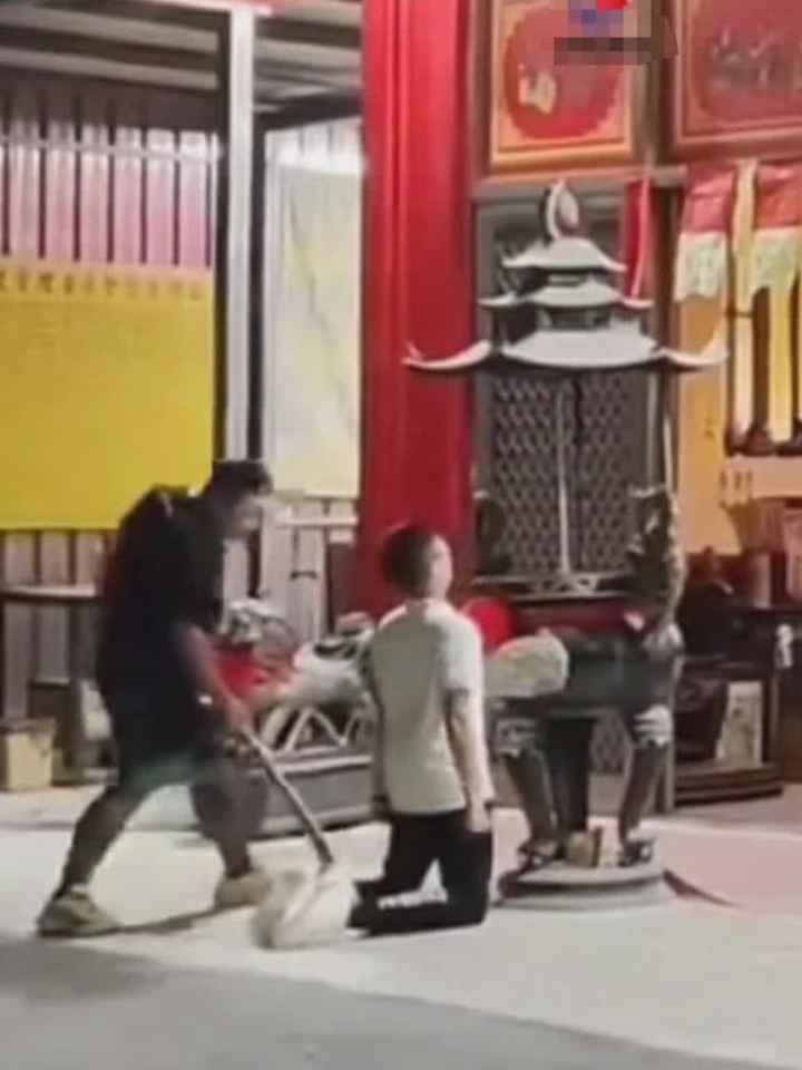 男孩犯错跪在祠堂门前 被父亲手持木棍狠狠抽打